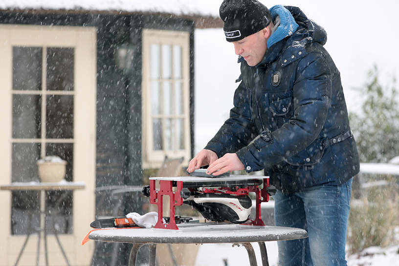 Een meneer die schaatsen aan het slijpen is